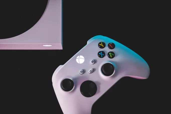 An Xbox Series S controller, next to its home controller.