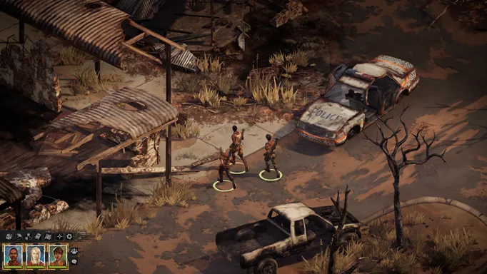 a gameplay screenshot of Broken Roads showing three characters amongst some broken down cars