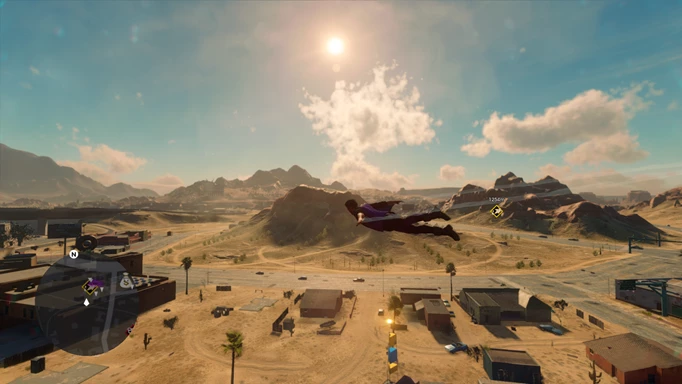 Flying through the air with a wingsuit, above some houses in the desert