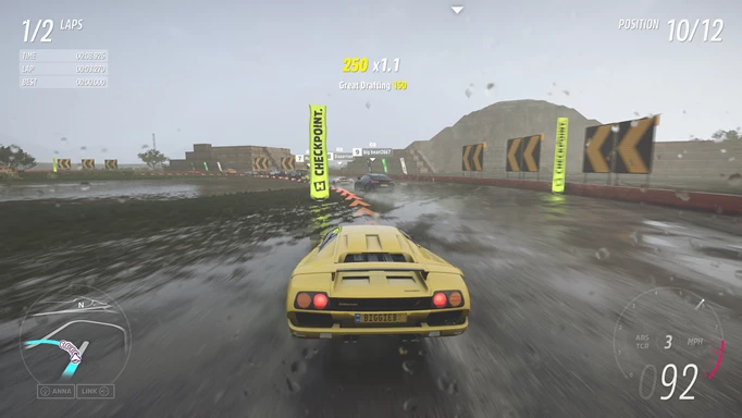 A yellow car speeds around a wet track.