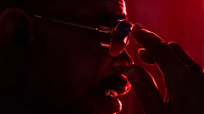 Blade fixing his glasses, with his fangs showing