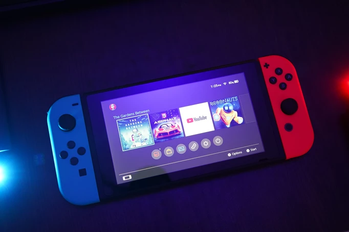 A Nintendo Switch console, lit up ready to play The Gardens Between.