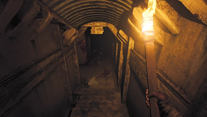 an image of Amnesia: The Bunker gameplay, showing the character descending stairs with a lit torch