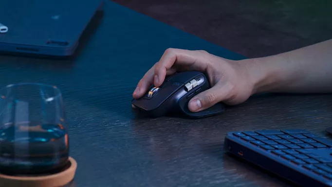 A close-up shot of a man using the MX Master 3S mouse.